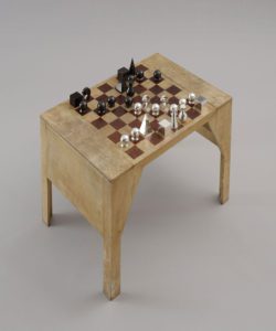 Tavolino da scacchi (1929) con pedine disegnate da Man Ray (1920-26).