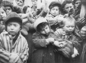 Dopo la liberazione di Auschwitz. Bambini che fanno vedere I numeri tatuati sulle braccia.