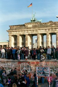 Giovani sul muro di Berlino davanti alla porta di Brandeburgo 10 novembre 1989