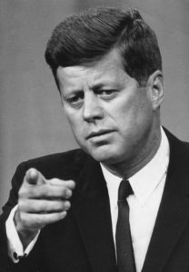 John F. Kennedy (1917-1963), trentacinquesimo presidente degli Stati Uniti d'America. Foto in bianco e nero a mezzo busto con il presidente che indica direttamente gli spettatori
