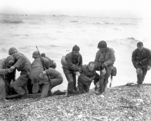 D Day, invasione di Normandia. Soldati americani aiutano altri soldati americani la cui scialuppa era stata affondata. D-day del 6 giugno 1944 e' stata l'invasione navale piu' grande della storia, con 156,000 truppe tra inglesi, americani e canadesi. Subirono 12,000 feriti e piu' di 4000 morti.