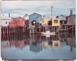 Edward Weston, Waterfront, Monterey. 1946. [red/blue/yellow buildings, piers, reflections] - CC00108