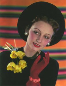 Donna che indossa un abito nero chic con guanti rossi e uno spruzzo di tulipani gialli sulla spalla. Mary Evans Picture Library - Londra Gran Bretagna