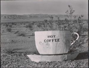 Hot Coffee, Mojave Desert. 1937. [oversized coffee mug with 'hot coffee' in black lettering; desert in background]. photo by Edward Weston