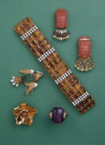 Parure Cartier con braccialetto, due spille in corallo con testa di donna, una spilla a forma di uccello, una a forma di fiore anello cabochon di ametista in stile precolombiano