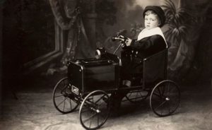 Michael Cole, Young boy in toy car, 1900. - E173681