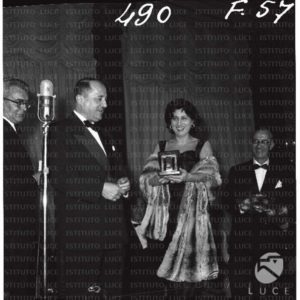 Anna Magnani ripresa mentre riceve il nastro d'argento sul palco - totale. Cerimonia di consegna dei Nastri d'Argento. 10.02.1957