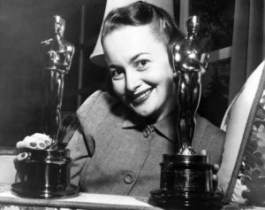 Olivia De Havilland con i suoi due premi Oscar per "A ciascuno il suo" (1946) e "L'ereditiera" (1949)