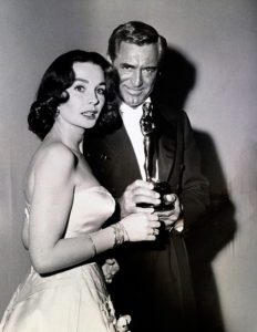 30° Annual Academy Award (1957), Jeanne Simmons raccoglie, per conto di Alec Guinness, il premio come miglior attore per 'Il ponte sul fiume Kwai'. Cary Grant presenta il premio come miglior attore.