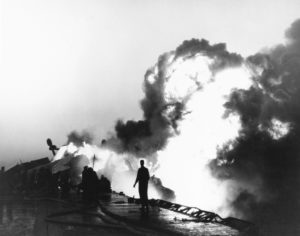 Shipboard fire in the Korean War. Flames and smoke billowing from fires on the flight deck near the starboard bow of the US Navy aircraft carrier USS Essex (CV-9) - SP28790