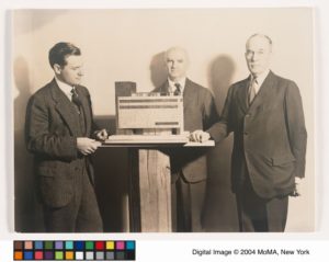 Model for The Museum of Modern Art Building with the Museum's Building Committee, left to right: Nelson A. Rockefeller, Treasurer; A. Conger Goodyear, President; and Stephen C. Clark, Trustee and Chairman of the Building Committee, 1937. Building was completed in completed in 1939 - 0131847