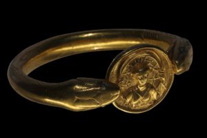 Gold bracelet with 2 snake heads holding a portrait medallion, found on the arm of a female victim of the 79 AD Vesuvius eruption, in the House of the Golden Bracelet, or Casa del Bracciale d'Oro, in the Parco Archeologico di Pompei, or Archaeological Park of Pompeii