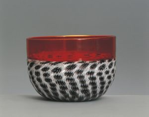 Glassware - Italy - 20th century. Incalmo bowl. Opaque white 'lattimo' and black glass paste mosaic 'murrine'. Ruby crystal rim. Designer Carlo Scarpa (1906-1978). Manufacturer Venini & C., 1957. Private Collection - DE21441